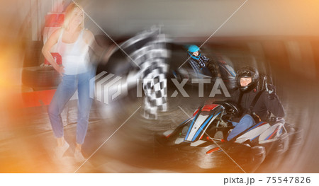 Male racer crossing finish line on kart track 75547826