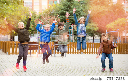 Happy kids jump and play outside 75547828