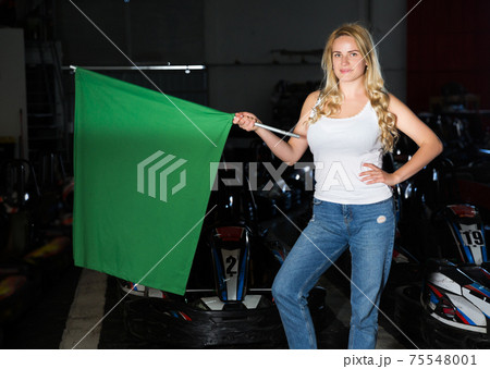girl holding green flag at kart racing track 75548001