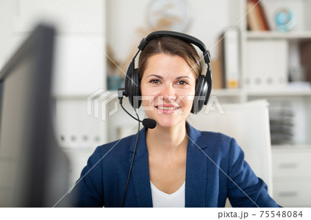 Portrait of smiling woman helpline operator with headphones Portrait of smiling woman helpline operator with headphones 75548084