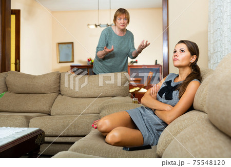 Mature female scolding her upset daughter 75548120