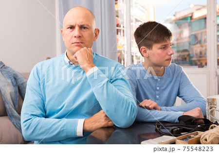 Father and teenage son after quarrel 75548223