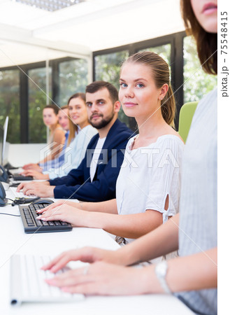 Side view of row of active people working Side view of row of active people working 75548415