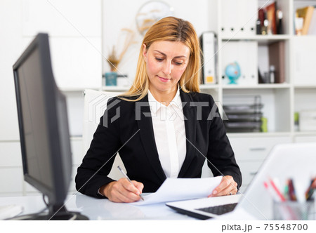 Young adult woman working at office Young adult woman working at office 75548700