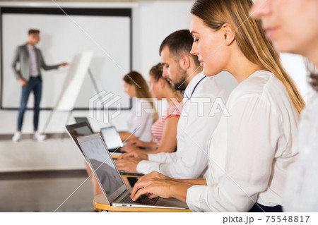 Side view of people with laptops Side view of people with laptops 75548817