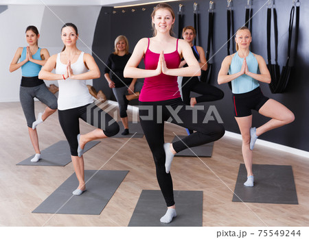 Women practicing yoga at gym 75549244