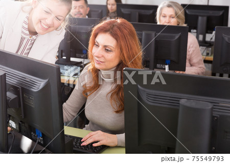 Focused mature woman taking computer lessons Focused mature woman taking computer lessons 75549793