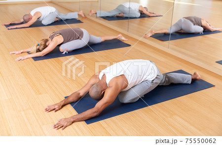 People making stretching and relaxing exercise in fitness studio People making stretching and relaxing exercise in fitness studio 75550062