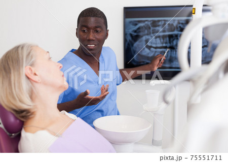 Doctor dentist shows patient an x-ray Doctor dentist shows patient an x-ray 75551711