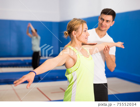 Instructor holding training with woman in trampoline room Instructor holding training with woman in trampoline room 75552034