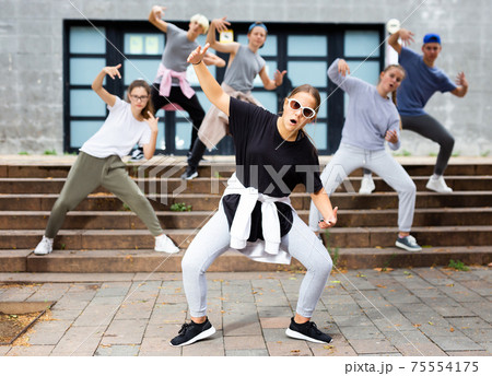 Active girls and boys dancing hip hop on a street Active girls and boys dancing hip hop on a street 75554175