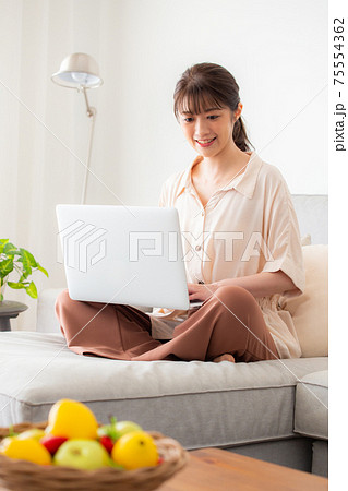 ソファでパソコンを使う女性 ソファでパソコンを使う女性 75554362