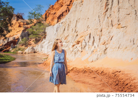 Woman tourist on the Fairy stream among the red dunes, Muine, Vietnam. Vietnam opens borders after quarantine COVID 19 75554734