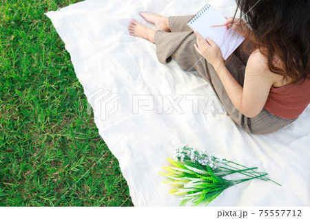 woman alone resting on a picnic in nature park outside at sunny day  enjoying summertime and dreaming woman alone resting on a picnic in nature park outside at sunny day  enjoying summertime and dreaming 75557712