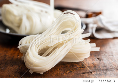 Dried white rice noodles. Raw pasta. Uncooked noodles. 75558013