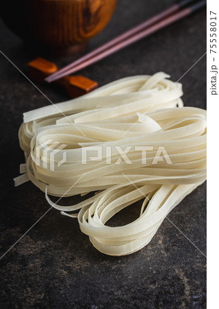 Dried white rice noodles. Raw pasta. Uncooked noodles. 75558017