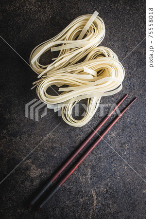 Dried white rice noodles. Raw pasta. Uncooked noodles. 75558018