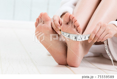 足の甲のサイズを測る女性 足の甲のサイズを測る女性 75559589