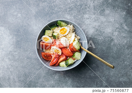 Cous cous salad with cucumber, cherry tomato and quail eggs. 75560877