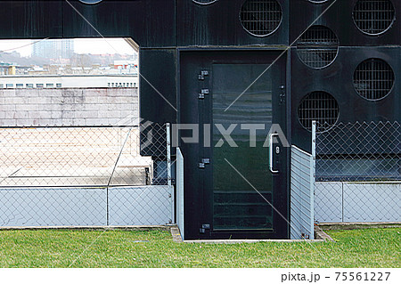 Small dirty black door to artistic modern building Small dirty black door to artistic modern building 75561227