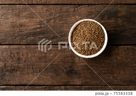 Caraway in bowl on retro wooden background. Top view 75563338