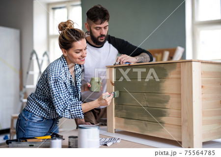 Mid adults couple painting furniture indoors at home, relocation and diy concept. 75564785