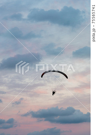 paramotor flight in vertical sunset sky 75565741