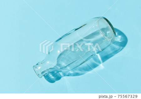 Empty class bottle on blue background. Zero waste concept Empty class bottle on blue background. Zero waste concept 75567329
