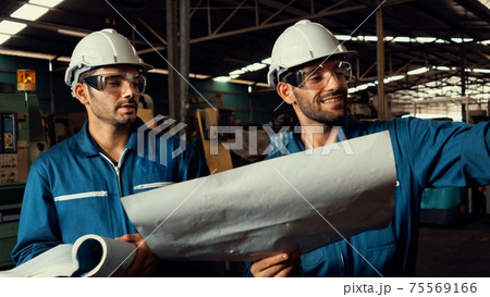 Group of skillful factory workers using machine equipment in workshop Group of skillful factory workers using machine equipment in workshop 75569166