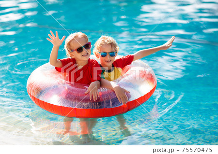 Kids in swimming pool. Life jacket for child. 75570475