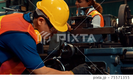 Group of skillful workers using machine equipment in factory workshop 75571355