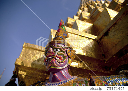 Demon Guardian statue against a blue sky in Wat Phra Kaew (Temple of the Emerald Buddha), Grand Palace in Bangkok, Thailand. 75571495