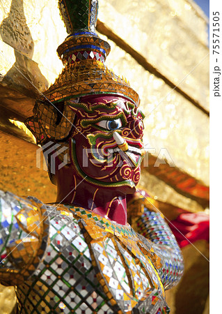 Demon Guardian statue against a blue sky in Wat Phra Kaew (Temple of the Emerald Buddha), Grand Palace in Bangkok, Thailand. 75571505