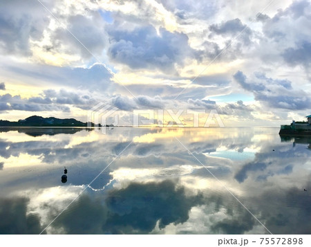 水面が空をきれいに反射している海の写真素材