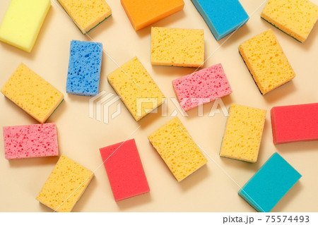 Sponges of different colors on a beige background. Sponges of different colors on a beige background. 75574493