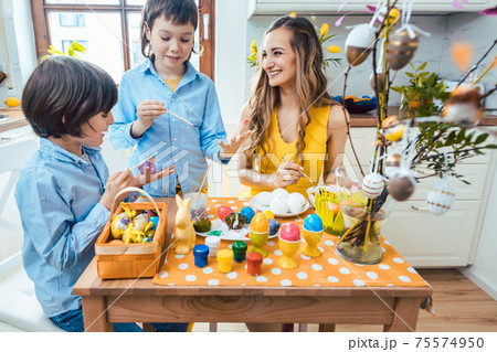 Mother and sons coloring eggs for Easter Mother and sons coloring eggs for Easter 75574950