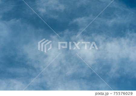 Reflections warm rays setting sun, swirls strong gust wind, outdoors. Bright blue sky, white translucent feathery clouds. Reflections warm rays setting sun, swirls strong gust wind, outdoors. Bright blue sky, white translucent feathery clouds. 75576029