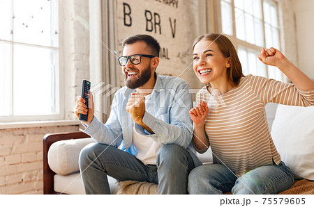 Happy couple celebrating victory while watching TV 75579605