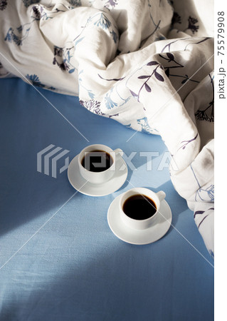 two cups of coffee in bed, sunlight 75579908