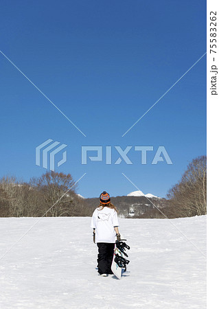 スノボを持って立つ若い女性 スノーボードイメージ スノボを持って立つ若い女性 スノーボードイメージ 75583262