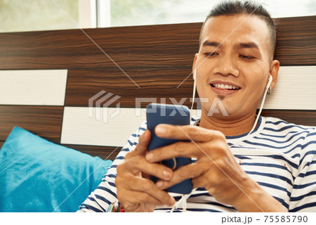 Cheerful man texting Cheerful man texting 75585790