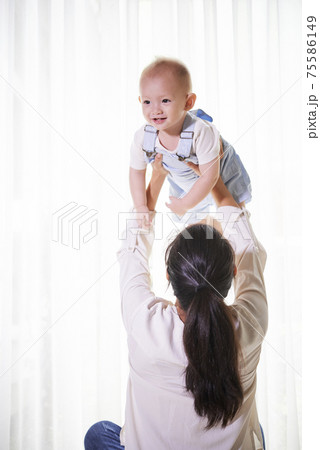 Mother lifting little son Mother lifting little son 75586149