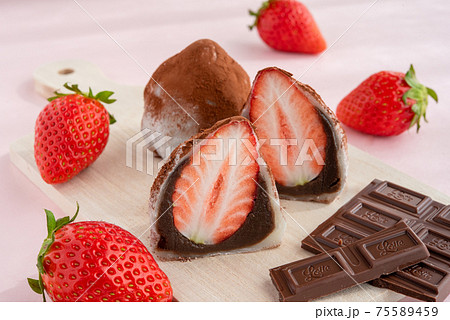 カッティングボードに乗ったチョコのいちご大福 背景にいちご チョコレートの写真素材