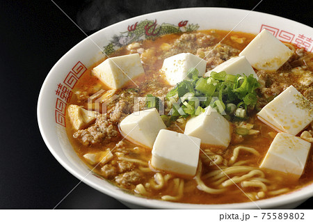 万能ねぎが沢山のっている山椒入りの熱々麻婆豆腐ラーメンを黒背景で撮影 75589802