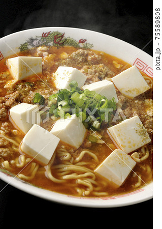 万能ねぎが沢山のっている山椒入りの熱々麻婆豆腐ラーメンを黒背景で撮影 75589808