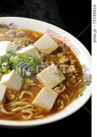 万能ねぎが沢山のっている山椒入りの熱々麻婆豆腐ラーメンを黒背景で撮影 75589810