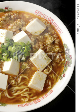 万能ねぎが沢山のっている山椒入りの熱々麻婆豆腐ラーメンを黒背景で撮影（俯瞰） 75589834