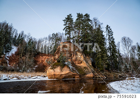 Zvartas red rock and river Amata at city Cesis in Latvia. Winter photo 75591023