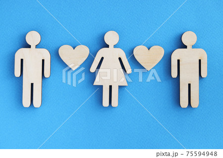 Wooden figurines of men and women with hearts on blue background 75594948