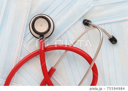 Stethoscope lies on medical protective masks closeup Stethoscope lies on medical protective masks closeup 75594984